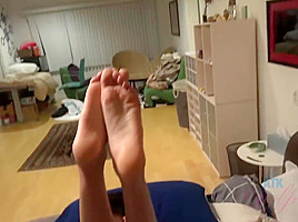 Ebony babe with dark, curly hair and small tits is giving a footjob to her roommate