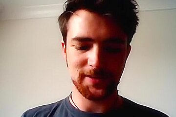 Handsome man is relaxing within doors and shooting himself on web cam