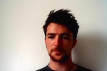 Handsome man is relaxing within doors and shooting himself on web cam