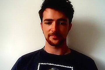 Handsome man is relaxing within doors and shooting himself on web cam