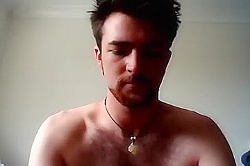 Handsome man is relaxing within doors and shooting himself on web cam