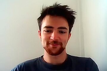 Handsome man is relaxing within doors and shooting himself on web cam