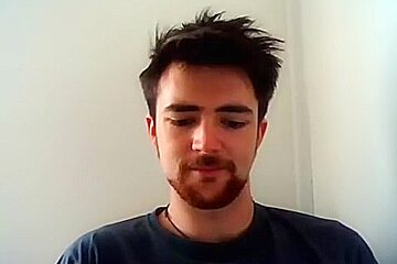 Handsome man is relaxing within doors and shooting himself on web cam
