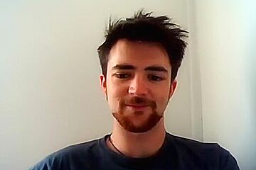 Handsome man is relaxing within doors and shooting himself on web cam