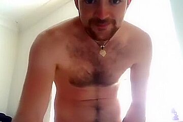 Handsome man is relaxing within doors and shooting himself on web cam