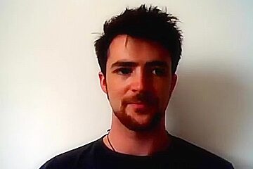 Handsome man is relaxing within doors and shooting himself on web cam
