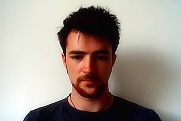 Handsome man is relaxing within doors and shooting himself on web cam