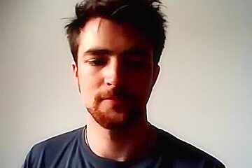Handsome man is relaxing within doors and shooting himself on web cam