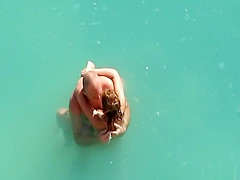 Nude couple fucking in water