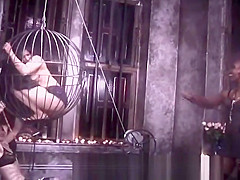 Two kinky mistresses take it out on a caged brunette slave