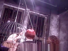 Two kinky mistresses take it out on a caged brunette slave
